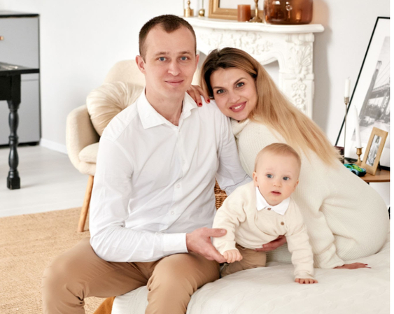 Newborn family photos showing a baby resting on a textured blanket with parents.