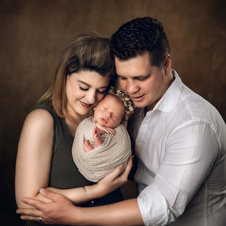 Family pictures with a newborn captured in a classic pose with parents holding baby