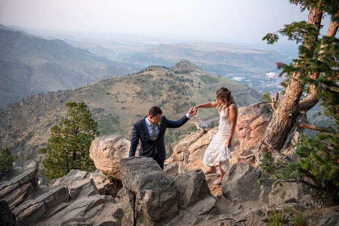 couple sitting on a scenic overlook shot by a colorado elopement photographer