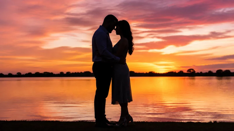 couple touching foreheads against a colorful sunset