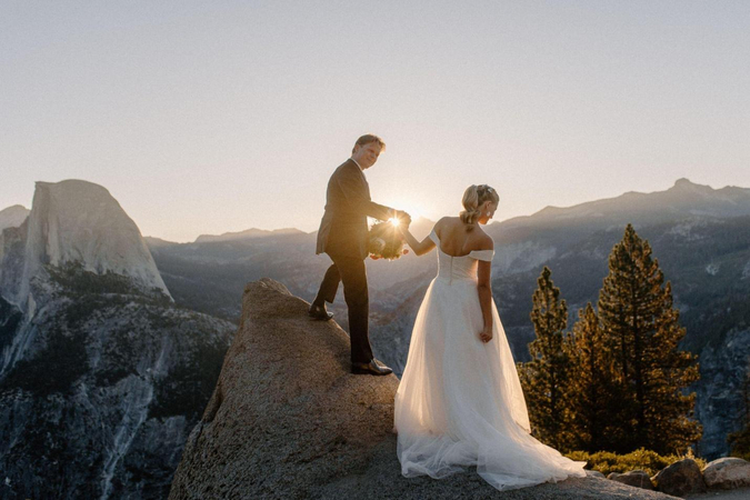 couple posing back to back with an outdoor elopement photographer