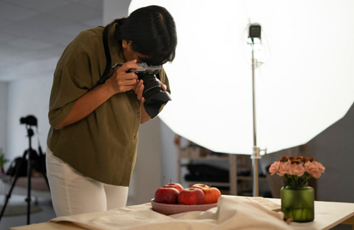 a boy takes photograph of apples in continuous lighting
