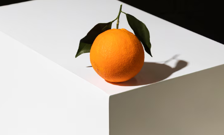 an orange on white table