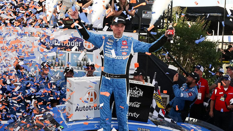 On July 20, 2025, in Dover, Delaware, Denny Hamlin celebrates in Victory Lane after winning the Autotrader EchoPark Automotive 400 at Dover Motor Speedway in the NASCAR Cup Series.