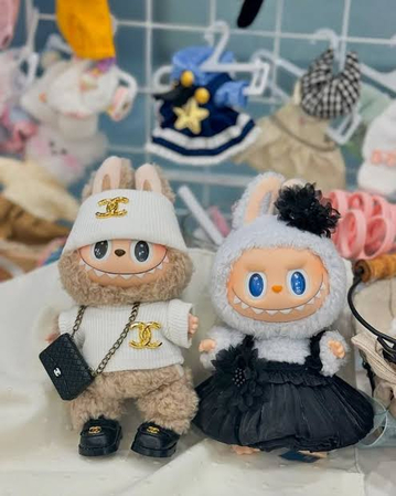 라부부 인형이 Chanel 및 Prada 고급 패션 의상을 입고 있음