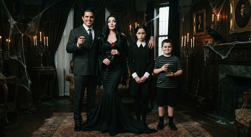 Family of four wearing gothic black Addams Family attire with spooky props