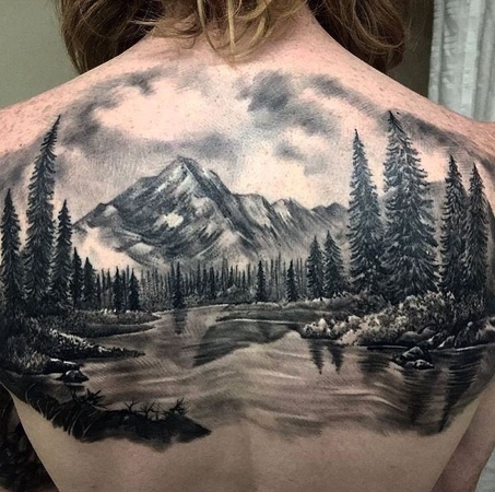 tatuagem de cobertura na parte inferior das costas com montanha